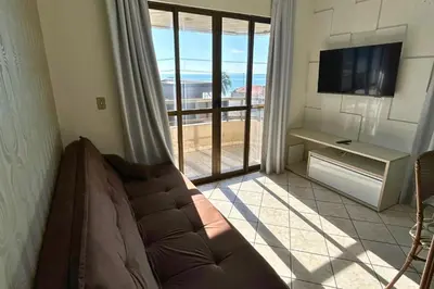 Uma televisão e/ou sistema de entretenimento em Apartamento com vista mar sobre a avenida