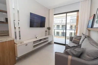 Uma televisão e/ou sistema de entretenimento em 139C - lindo apartamento a 50m da praia de Canto Grande