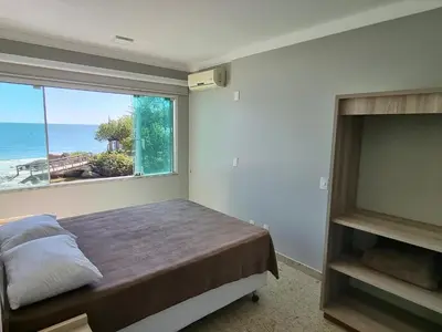 Uma cama ou camas num quarto em triplex beira mar de bombinhas