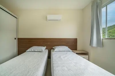 Uma cama ou camas num quarto em Ap 3 quartos (1 suíte) com ar e sacada gourmet – Bombas
