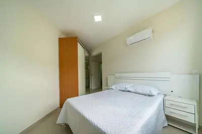 Uma cama ou camas num quarto em Ap 3 quartos (1 suíte) com ar e sacada gourmet – Bombas