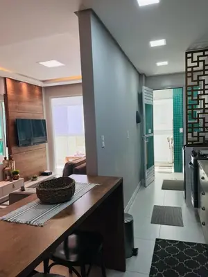 Uma televisão e/ou sistema de entretenimento em Apartamento na Praia de Palmas com garagem