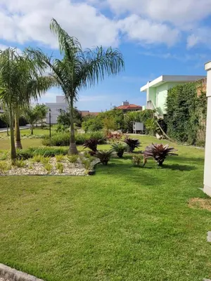 Um jardim no exterior de Sobrado com garagem e churrasqueira