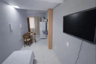 Uma televisão e/ou sistema de entretenimento em Apto Térreo Privativo com Piscina Ar condicionado e vaga de estacionamento em Itapema