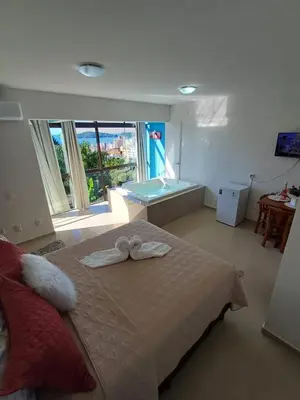Uma cama ou camas num quarto em Suíte Atlântica com banheira de hidromassagem