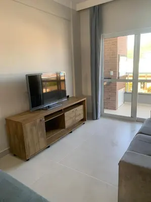 Uma televisão e/ou sistema de entretenimento em Apartamento de Praia em Bombinhas