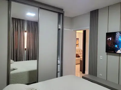 Uma cama ou camas num quarto em Sinta-se em Casa, Apartamento luxo 2 suítes, piscina aquecida no condomínio, 1 quadra do mar, completo