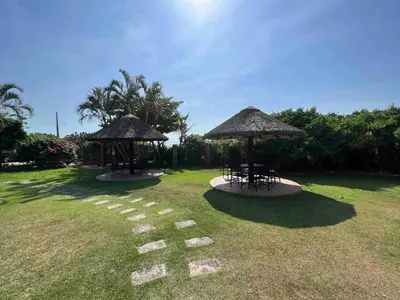 Um jardim no exterior de Casa pé na areia em praia paradisíaca com piscina frente mar