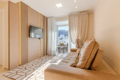 Uma televisão e/ou sistema de entretenimento em Aconchegante Apartamento para Famílias na Praia de Bombinhas - Centro