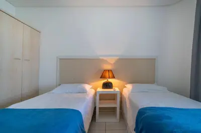 Uma cama ou camas num quarto em A08 - Laélia Purpurata - Apartamento frente mar 03 dormitórios