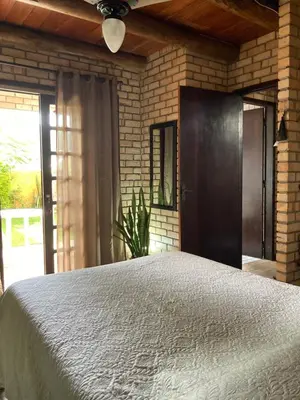 Uma cama ou camas num quarto em Quarto com banheiro privativo em Chalé Aconchegante.