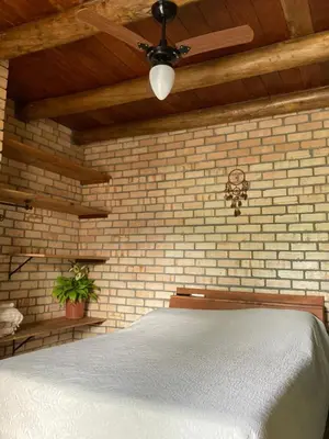 Uma cama ou camas num quarto em Quarto com banheiro privativo em Chalé Aconchegante.