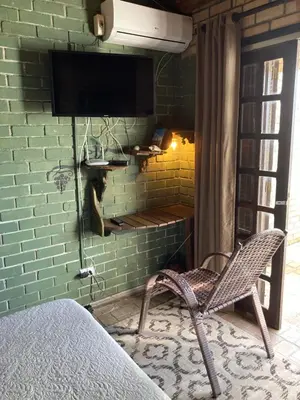 Uma televisão e/ou sistema de entretenimento em Quarto com banheiro privativo em Chalé Aconchegante.