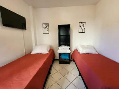 Uma cama ou camas num quarto em Sobrado 30 m praia, quartos climatizados, 1 vaga, até 6 pessoas