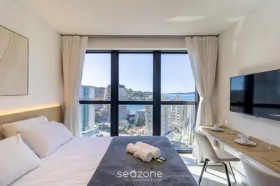 Uma cama ou camas num quarto em MHFA - Studios em Prédio Luxuoso com Vista Mar