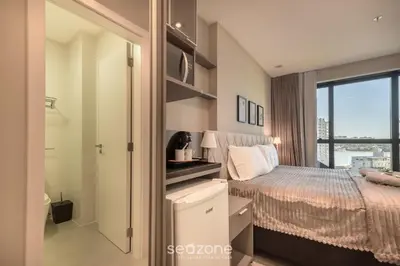 Uma cama ou camas num quarto em MHFA - Studios em Prédio Luxuoso com Vista Mar