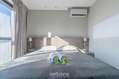 Uma cama ou camas num quarto em MHFA - Studios em Prédio Luxuoso com Vista Mar