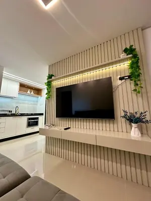 Uma televisão e/ou sistema de entretenimento em Apto Itapema NOVO 2 quartos e 2bwc -2 garagens - Prédio com Piscina