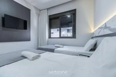 Uma cama ou camas num quarto em DRL - Apartamentos a 300m da Praia de Bombinhas