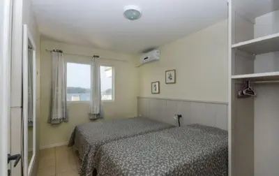 Uma cama ou camas num quarto em APARTAMENTO NO CENTRO DE BOMBINHAS COM VISTA MAR - ap 303