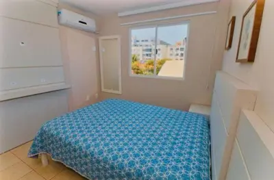 Uma cama ou camas num quarto em Apartamento no Centro de Bombinhas Prédio na avenida Principal - ao lado de comércio em geral