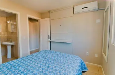 Uma cama ou camas num quarto em Apartamento no Centro de Bombinhas Prédio na avenida Principal - ao lado de comércio em geral