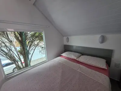 Uma cama ou camas num quarto em Residencial Chalés Rota do Sol Bombinhas - com cozinha
