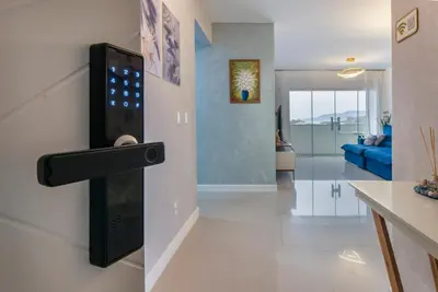 Uma televisão e/ou sistema de entretenimento em Encantador Apartamento 100m da Praia com vista mar