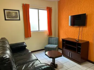 Uma televisão e/ou sistema de entretenimento em 324 - Apartamento confortável na praia de Bombas