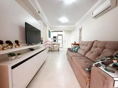Uma televisão e/ou sistema de entretenimento em Apartamento para aluguel de temporada Bombas,SC