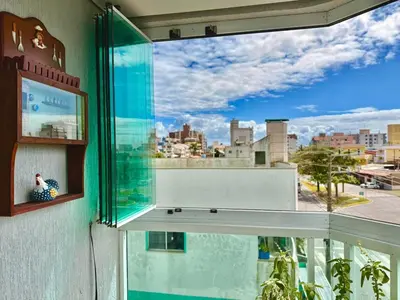 Uma varanda ou terraço em SOLAR DE BOMBAS - 3 quartos a 280m da praia c roupa de cama - Sacada com Churrasqueira - climatizado - 10 min a pé da passarela do Ribeiro e acesso a Praia de Bombinhas - 5 min a pé de supermercados - Até 8 pessoas, ideal p famílias, grupos, crianças