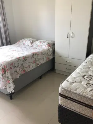 Uma cama ou camas num quarto em Bombinhas Residencial Ecomar