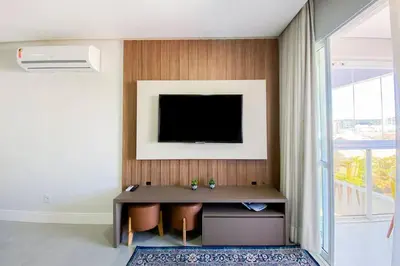 Uma televisão e/ou sistema de entretenimento em Apartamento poucos metros da praia de Palmas - 0112