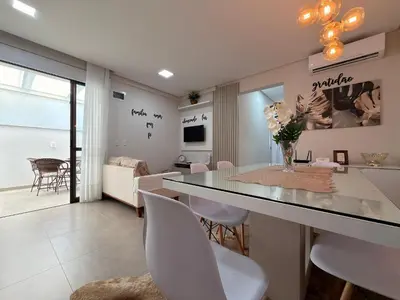 Uma televisão e/ou sistema de entretenimento em Residencial Benjamin - Apartamento garden a 2 minutos da praia de Palmas, com espaços internos e externos amplos para até 8 pessoas