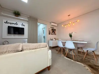 Uma televisão e/ou sistema de entretenimento em Residencial Benjamin - Apartamento garden a 2 minutos da praia de Palmas, com espaços internos e externos amplos para até 8 pessoas