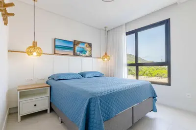 Uma cama ou camas num quarto em Apartamento alto padrão com piscina em Bombinhas
