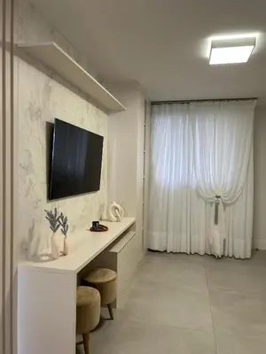 Uma televisão e/ou sistema de entretenimento em Apartamento novo frente mar