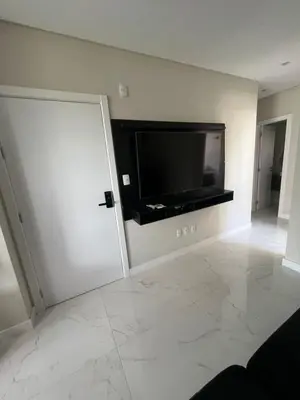 Uma televisão e/ou sistema de entretenimento em Apto com 3 suites na quadra do mar em Meia Praia Itapema