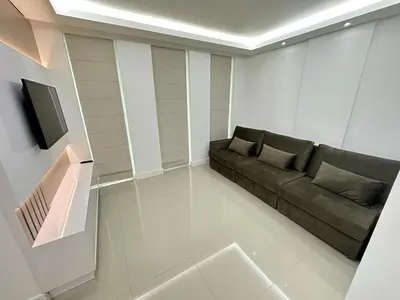 Uma televisão e/ou sistema de entretenimento em Apartment Meia Praia 3 Suites