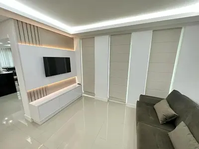 Uma televisão e/ou sistema de entretenimento em Apartment Meia Praia 3 Suites