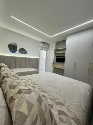Uma cama ou camas num quarto em Apartamento no coração de Meia Praia, com 4 Suítes e 3 vagas de garagem