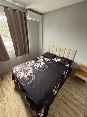 Uma cama ou camas num quarto em Hospedagem da Marli Bombinhas