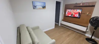 Uma televisão e/ou sistema de entretenimento em Casa da Sil com garagem, ar, wifi, perto Expocentro