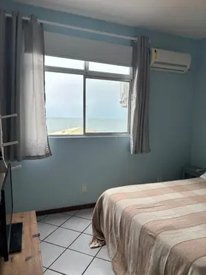 Uma cama ou camas num quarto em Amplo Apê VIsta para o Mar de Bombas