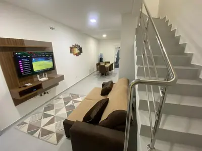 Uma televisão e/ou sistema de entretenimento em Sobrado aconchegante no litoral