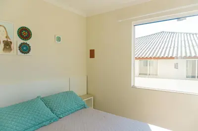Uma cama ou camas num quarto em Quarto aconchegante privativo a 150m da praia