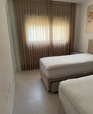 Uma cama ou camas num quarto em Apartamento meia praia itapema SC 3 suítes