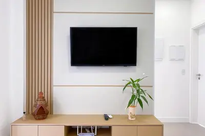 Uma televisão e/ou sistema de entretenimento em Apartamento há poucos metros da praia - 0459