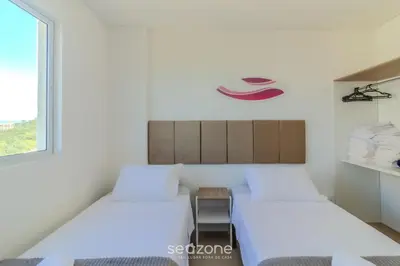 Uma cama ou camas num quarto em Apto 2Q c/ Churrasq. e vista 550m da Praia OMC1303