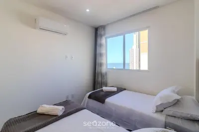 Uma cama ou camas num quarto em Apto 2Q c/ Churrasq. e vista 550m da Praia OMC1303